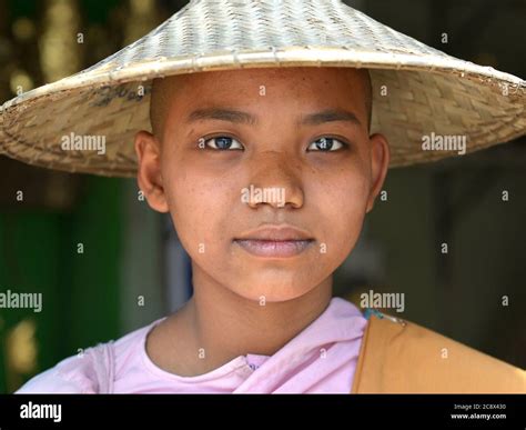 Young Burmese Buddhist nun with shaved head wears a traditional Asian ...