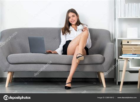 Beautiful secretary with sexy legs sit on sofa in office. Sexy business ...