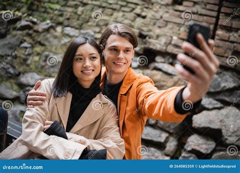 Smiling Man Hugging Asian Girlfriend while Stock Image - Image of positive, asian: 264085359