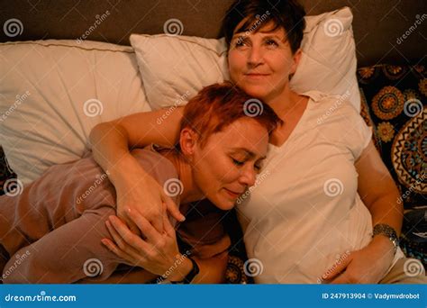 Mature Lesbian Couple Hugging and Smiling while Lying in Bed Stock ...