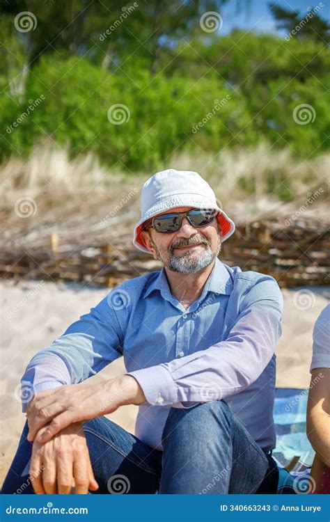 A 60-70-year-old Man Wearing Sunglasses and a Hat on the Beach Stock ...