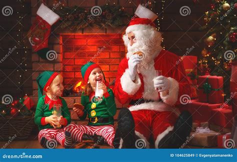 Christmas. Santa Claus with Elves Drink Milk and Eat Cookies Stock ...