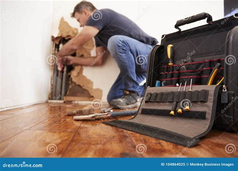 Middle Aged Man Repairing Burst Pipe,plumbing, Focus on Foreground ...