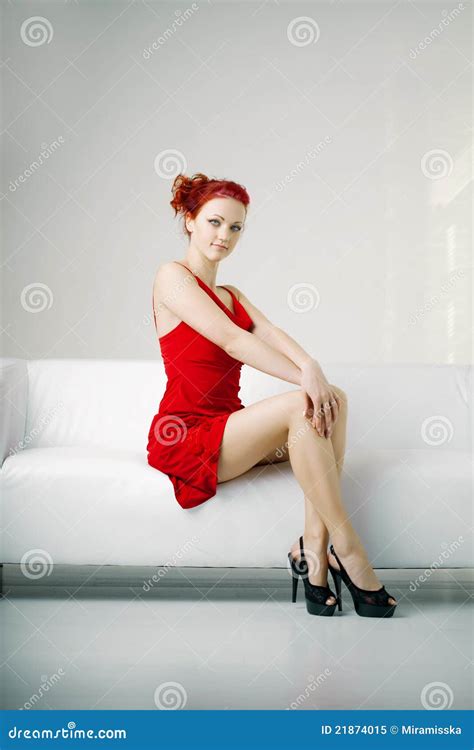 Redhead Woman in a Red Dress on White Couch Stock Image - Image of ...