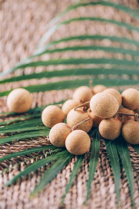 Premium Photo | Longan fruits over palm leaves on rattan background ...
