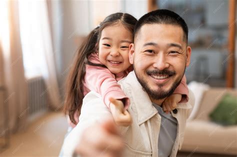 Premium Photo | Korean dad and baby daughter gesturing thumbs up at home