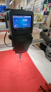With Aurifil thread and warm and natural batting, we stitched this festive pattern on our @berninausa Q24 using Q-matic software. Q-matic is like having your own elf to drive your longarm for you! You set it and it stitches! #bernina #aurifil #longarmquilting | Aurora Sewing Center