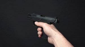 「ハンドガンをリロードし、弾薬クリップを挿入し、チャンバー内の弾丸を確認し、片手で照準を合わせる – 後ろから見る」の動画素材（ロイヤリティフリー）3460483539 | Shutterstock