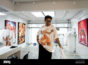 Bangkok, Thailand. 26th Mar, 2023. Burin Pong poses for a portrait next to his artowrk on display in the upstairs gallery space of I WANNA BANGKOK, a local Thai fashion brand. "BKK BOI" is the debut solo exhibition for artist Burin Pong, a 24-year old self-described gaymer that draws inspiration for his work by combining LGBTQ people as characters into fantasy gameplay intended to increase visibility of LGBTQIA people in video games. Credit: Matt Hunt/Neato/Alamy Live News Stock Photo - Alamy