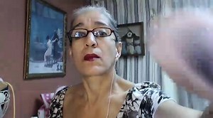 Seductive mature lady with glasses reveals her sexy legs on