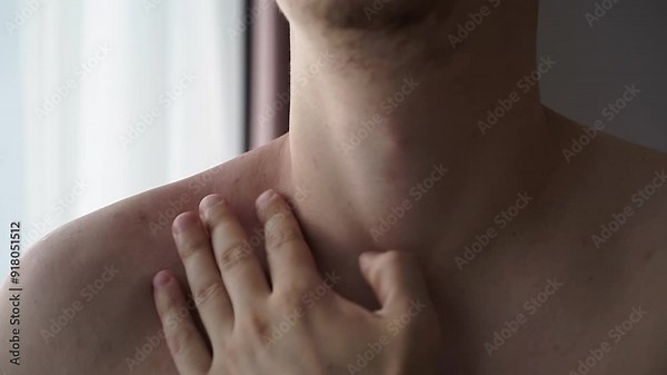 Close-up of a sore shoulder. A bare-chested man massages his arm to relieve pain in his arm.