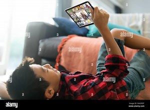 Asian boy using tablet for video call, with smiling diverse elementary school pupils on screen. communication technology and online education, digital Stock Photo - Alamy