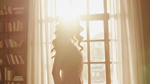 Woman in a library with natural sunlight | Premium Stock Video Footage