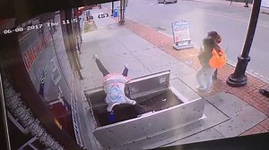 Shocking moment woman falls through trapdoor while texting