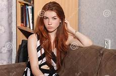 candid redhead sitting woman beautiful young sofa lady barefoot typical thoughtful portrait room background preview
