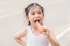 girl carrot eat asian little enjoy road stock girls preview
