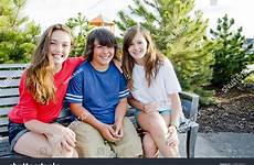 boy girls two sitting park bench shutterstock youths sunny smiling bright stock