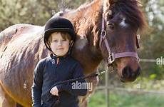pony boy standing outside young sunny countryside stock alamy walking rear son field mother smiling camera