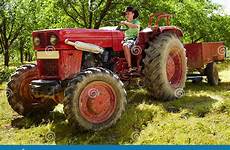 tractor driving teenager old boy teenage orchard hat trailer through