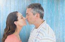 kissing mature couple plank against wooden background