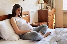 pregnant sitting bed woman holding stomach stock dissolve royalty d943