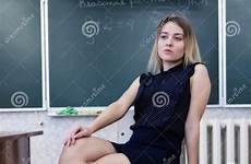 legs teacher strict blonde young chair her crossing sits classroom preview