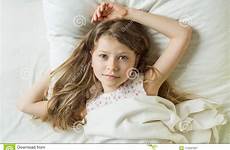 girl hair long blonde wakes wavy child smiles pillow lying angel camera bed face her preview