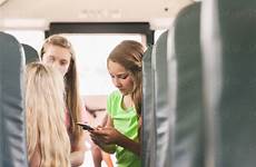 girls school bus stocksy talking cell phone united
