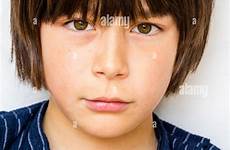 old year boy brown hair caucasian child facing shoulders head viewer staring defiant expression annoyed eye contact alamy stock