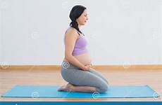 kneeling pregnant mat exercise brunette fitness stock