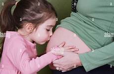 pregnant belly mother kissing alamy child