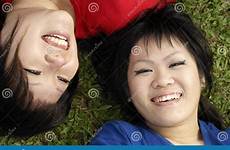 asian teen girls happy two royalty stock lying grass wearing blue red