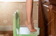 girl standing bathroom little tiptoes chair closeup preview