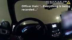 Police bodycam shows officer locked in back of car with female detainee
