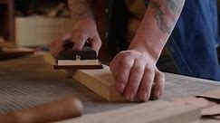 Craftsman Using Manual Sander on Wooden Plank