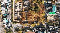 Aerial view of Gyeonggijeon Hall, traditional Korean architecture amidst autumn foliage in Jeonju Hanok Village, a cultural heritage site.