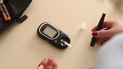 Close-up of a girl piercing his finger with a scarifier to check the level of glucose in the blood. Control diabetes at home with a glucometer. A drop of blood. Blood sampling for glucometer.