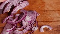 Chop the purple onion with a knife on a chopping board. Cut the onion into half rings