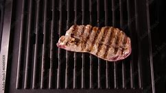Hot fried steak electric grill. Chef cook red well done meat. Man hold tongs flip beefsteak. Food preparing process. Fresh juicy tasty beef chops slices. Open air bbq party close up. Roasted steak.