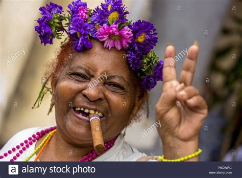 Hier lassen sich zigarren aus kuba vor ort rauchen und raritäten bestaunen. Peace-Zeichen, alte kubanische Frau mit Blumen und Zigarre ...