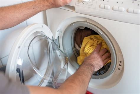 However, it is important to separate colors more thoroughly than darks to avoid staining from dyes. Man Loading Colored Clothes In Washing Machine Stock Photo ...