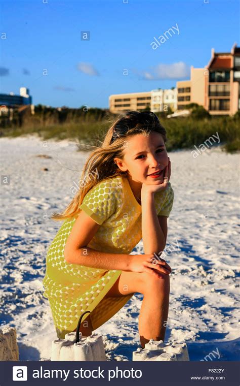 Start date oct 22, 2020. Young girl posing at sunset by the sand castle she built ...