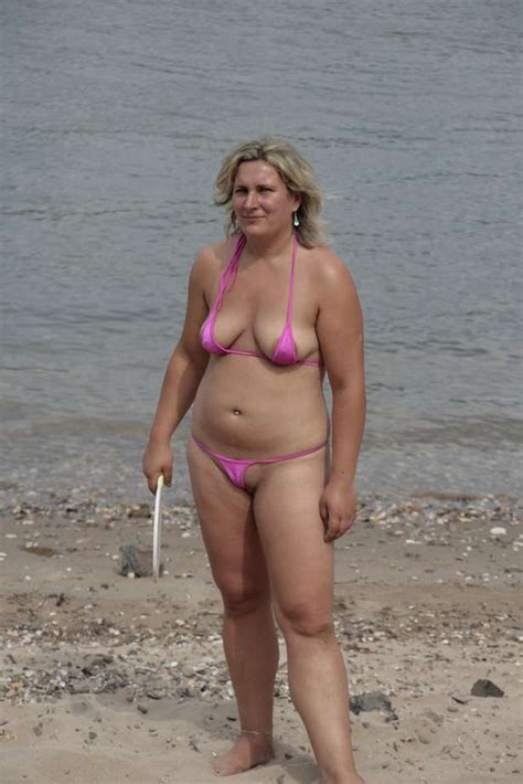 À la belle femme mature, quarantenaire, dont l'élégance féline vous rend toute chose dans le pantalon. Une mature blonde joue sur la plage avec son mini bikini ...