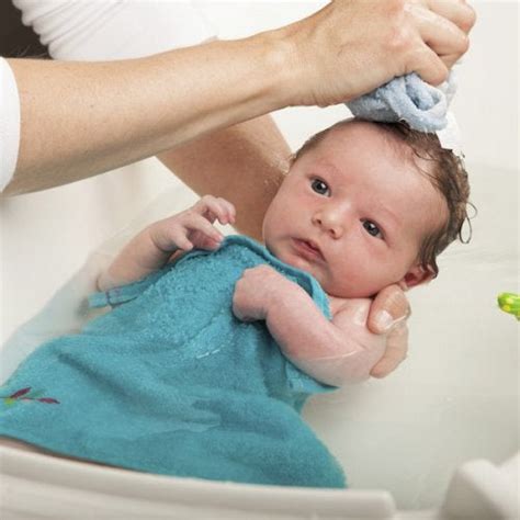 Place your baby in the diaper by gently lifting the baby's feet and legs and sliding the diaper under. Why You Should Not Bathe Your Baby After Birth - You are Mom