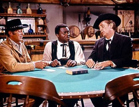 After a card shark is caught cheating, he is taken out and lynched by the drunkards he was playing against. Dean Martin, Yaphet Kotto and Robert Mitchum in "Five Card Stud" 1968