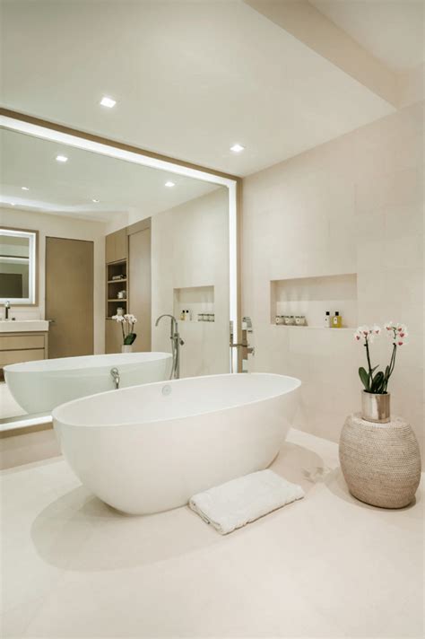 Baroque silver mirror over white wall. Big Bathroom Mirror Trend in Real Interiors