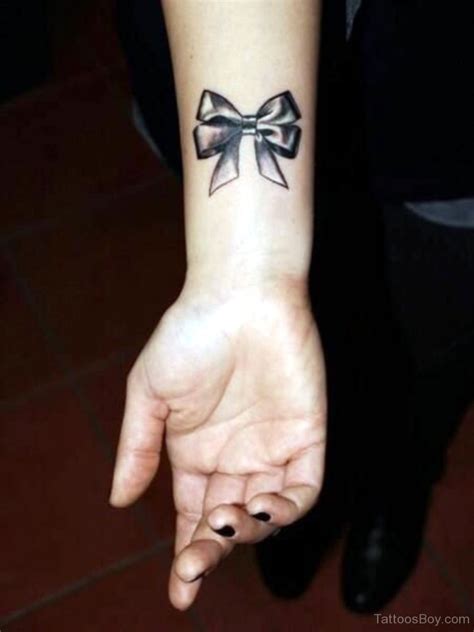 A black and gray bow is rendered on the back of the wearer's neck in this tattoo. Bow Tattoos | Tattoo Designs, Tattoo Pictures
