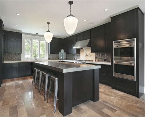 We love how the wood keeps this modern kitchen warm and welcoming, despite its cooler tones. Dark cabinets, grey countertops and light wood floors ...