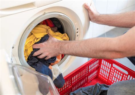 Wash your coloured clothes in cold water, no higher than 30°c. Man Loading Colored Clothes In Washing Machine Stock Image ...