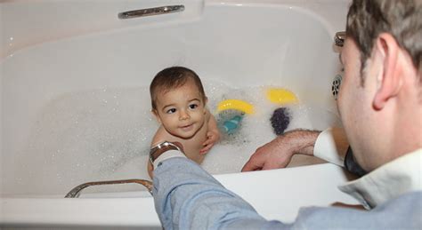 You could also try bathing in the sink, or from a tub of water. Baby Boy Taking A Bath With Foam With Help Of His Daddy ...